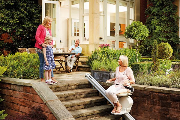 family looking at grandma outside enjoying an acorn stairlift